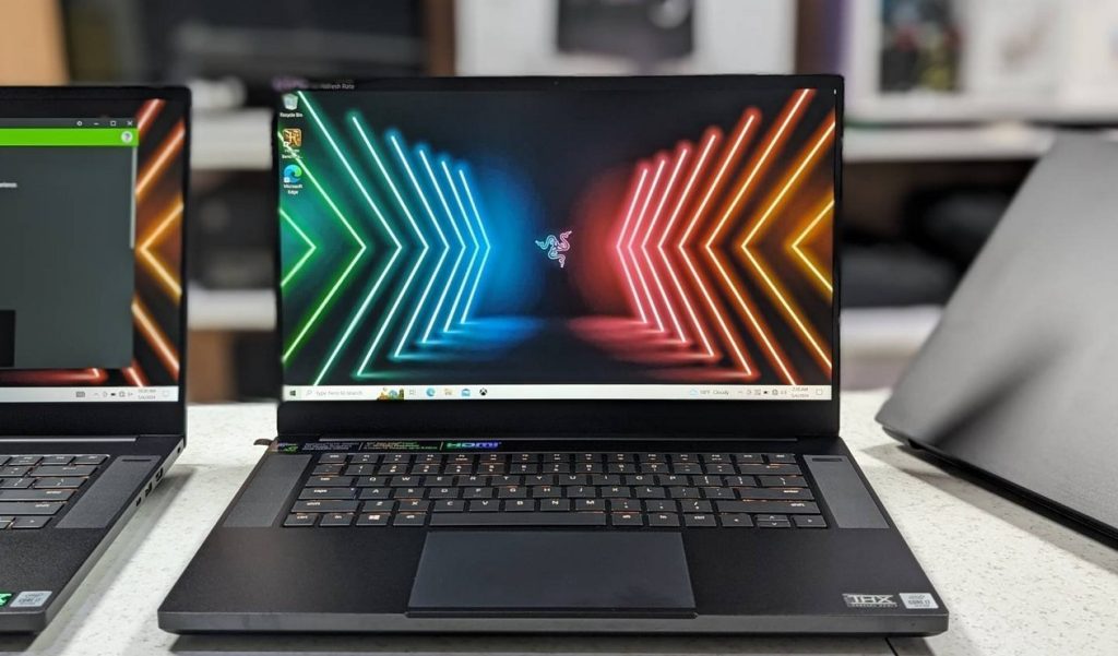 Close-up photo of Razer Blade 15 on the table. A mid-spec Razer Blade 15 on the left side, partially visible. Photo was taken while our team member were testing best day trading laptops.